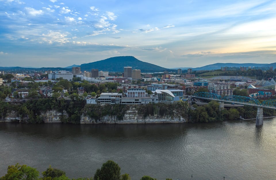 The downtown Chattanooga skyline seen across the Tennessee River, with a ridge of hills behind it