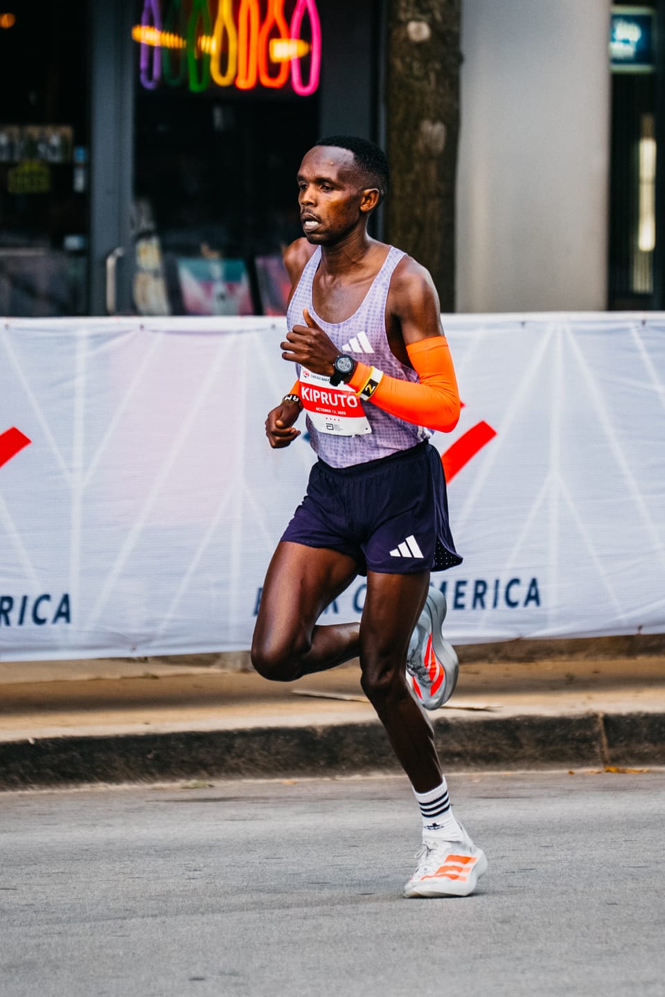 Amos Kipruto running in a red singlet during the 2025 Chicago Marathon