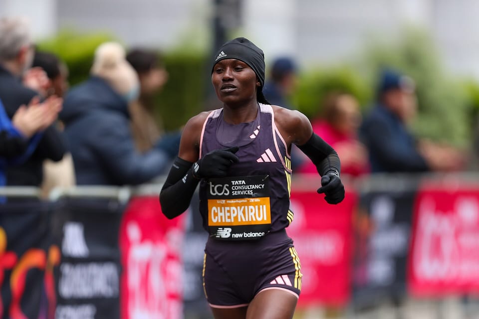 Sheila Chepkirui in a black hat and purple vest running past spectators at the London Marathon