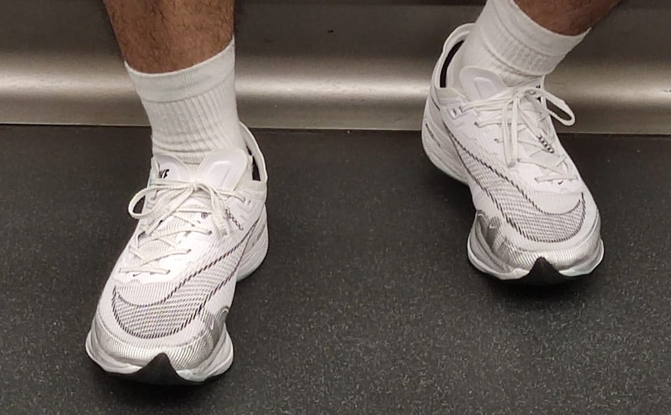 A runner’s feet in white Nike Vaporfly Next% racing shoes